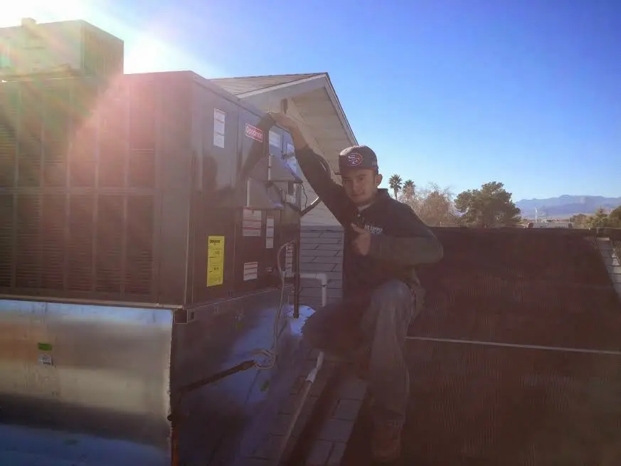 HVAC technician performing HVAC Inspection on a rooftop unit in Pinehurst